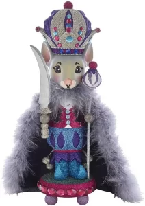figura de cascanueces de raton con una corona de rey, una capa, una espada y un bastón vetido de colores azul, morado y rosa.